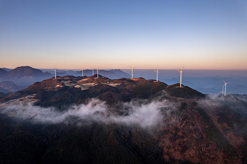 Terraced fields and wind turbines on the mountain at dusk
