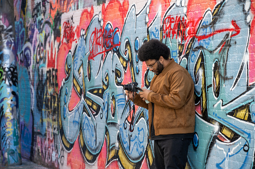 Baltimore, USA - February 17, 2024. A male photographer taking pictures at Graffiti Alley in Station North Arts & Entertainment District of Baltimore, Maryland, USA