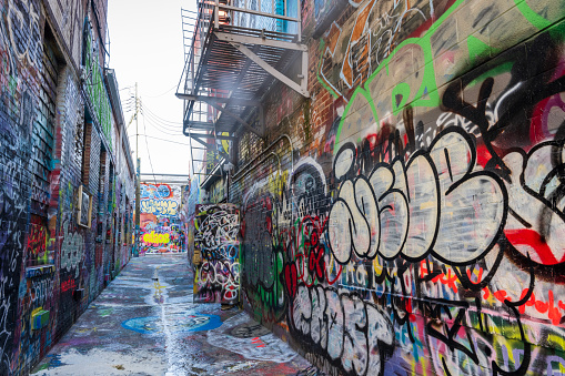 Ljubljana, Slovenia - August 21, 2020: A panorama picture of buildings with street art on display at the Metelkova Art Center. The artist's name is Raze.