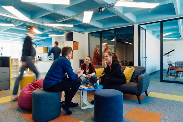 istock Multiethnic startup business team on meeting in a modern bright open space coworking office. Brainstorming, working on laptop. Group of coworkers walking around in motion blur 2059596482