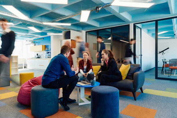 istock Multiethnic startup business team on meeting in a modern bright open space coworking office. Brainstorming, working on laptop. Group of coworkers walking around in motion blur 2059616714