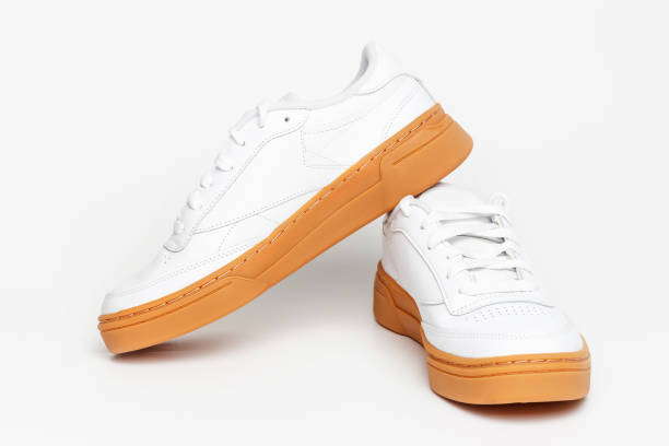 istock White sneaker with brown sole on white background close-up. 2059625580