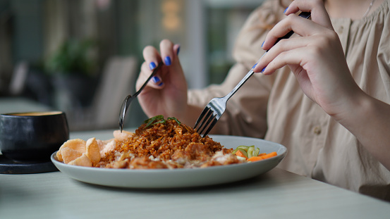 Asian women eating fried rice or well know as nasi goreng