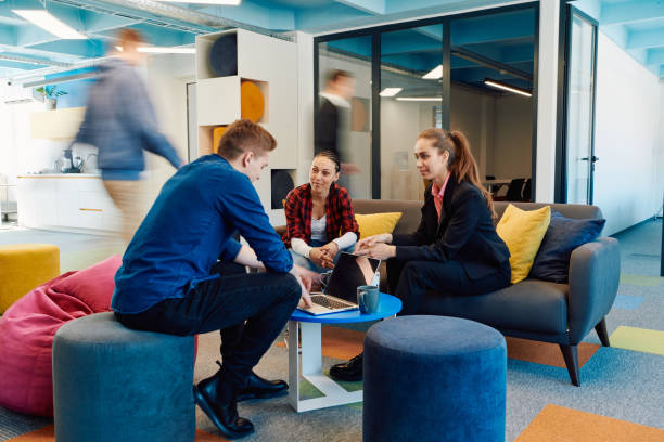 istock Multiethnic startup business team on meeting in a modern bright open space coworking office. Brainstorming, working on laptop. Group of coworkers walking around in motion blur 2059683257