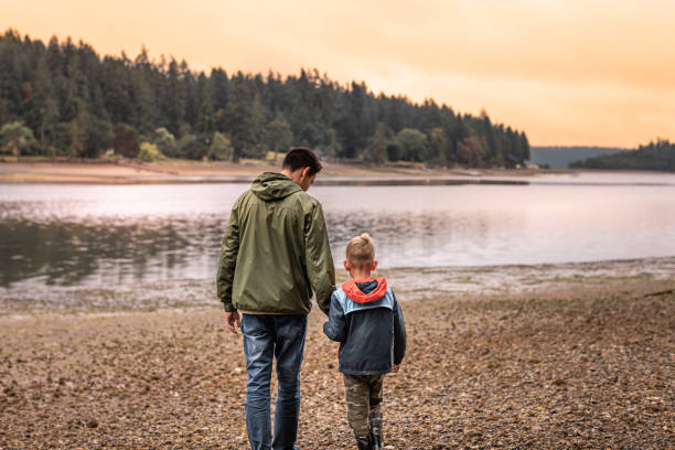 istock Father and son walking on the beach at sunset. 2059693248