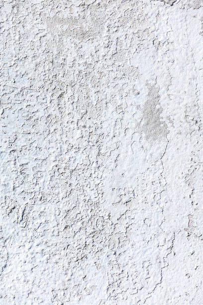istock weathered shabby white plaster wall background with peeling off paint. 2059699491