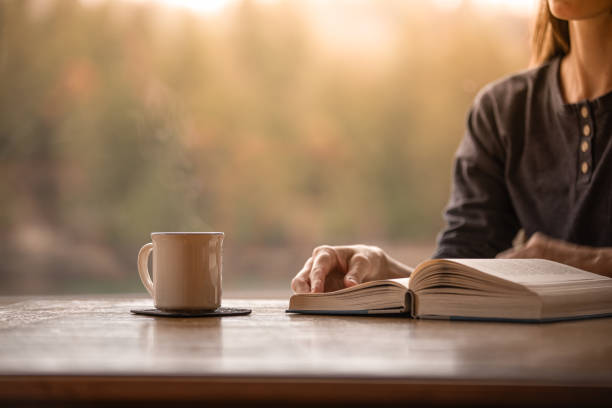 istock Woman reading a book and having a coffee  at home. 2059699792