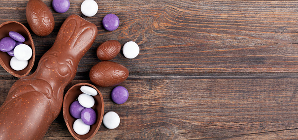 Chocolate Easter eggs and rabbit on rustic wooden background