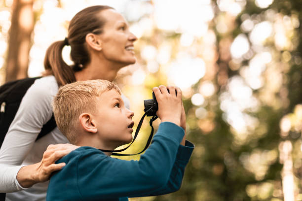istock Parent and child with binoculars in the forest. 2059748538