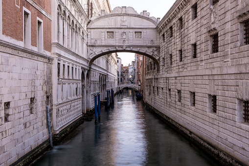 View of the Bridge of Sighs, an enclosed bridge made of white limestone and windows with stone bars, passing over the Rio di Palazzo in Venice, Italy