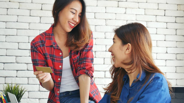 two friends shopping using credit card online shopping on website laptop e-commerce website with smiling face, happiness. happy asian women using laptop shopping online buy, payment newnormal concept - e commerce couple working at home internet zdjęcia i obrazy z banku zdjęć