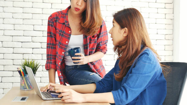 two friends shopping using credit card online shopping on website laptop e-commerce website with smiling face, happiness. happy asian women using laptop shopping online buy, payment newnormal concept - e commerce couple working at home internet zdjęcia i obrazy z banku zdjęć