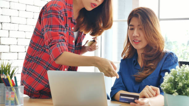 two friends shopping using credit card online shopping on website laptop e-commerce website with smiling face, happiness. happy asian women using laptop shopping online buy, payment newnormal concept - e commerce couple working at home internet zdjęcia i obrazy z banku zdjęć