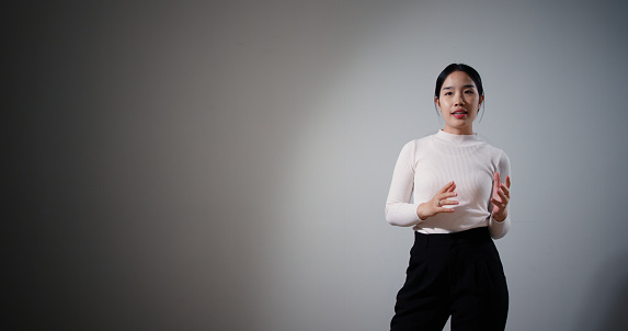 Selective focus, Female motivational speaker on stage talking and showing a presentation to audience, Startup conference, Business and entrepreneurship event, Talking about success and mindset