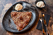 Ferrero Rocher Crepe with hot chocolate, whipped cream, knife and fork served in dish isolated on dark background closeup top view of cafe baked dessert food