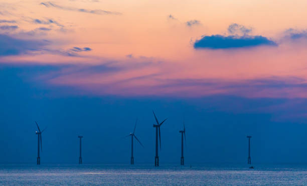 istock Offshore wind power generator visible on the horizon at sunset. 2059903926