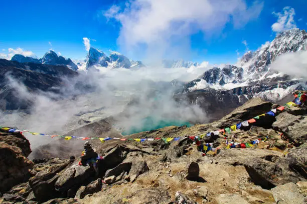 Clouds rising from the Ngozumpa glacier frame this ethereal image of a stunning Himalayan panorama visible from the summit of Gokyo Ri in Nepal