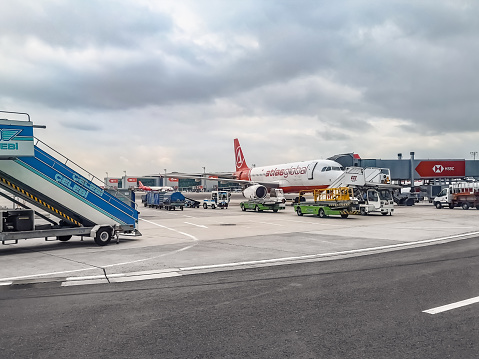 Istanbul, Turkey - October 28, 2019: Transport and service equipment near the Atlas Global aircraft on the runway at Istanbul airport. Maintenance of a passenger airplane near a modern terminal