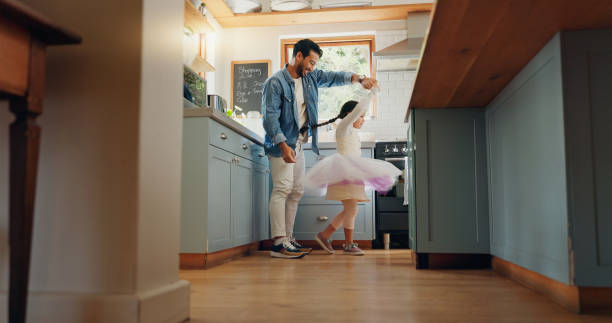 supporto, amore e balletto ragazza che si lega con il padre in una cucina insieme, eccitata e giocando come ballerina pr ballerina. tutù, papà e uomo che ballano con il bambino con motivazione o felicità in casa o a casa - padre foto e immagini stock