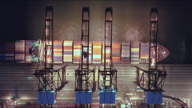 Aerial View of Container Terminal at Night with Cranes and Cargo.