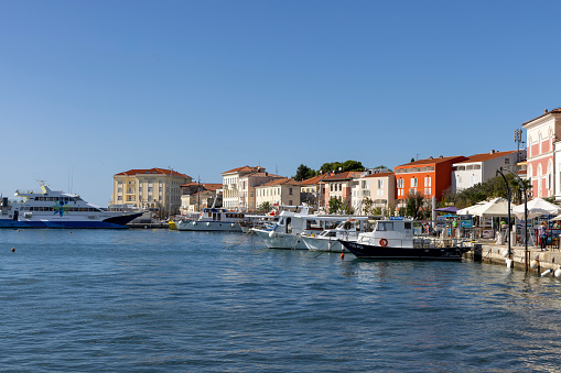 Porec, Croatia, Istria - September 25, 2023: Waterfront at Marshal Tito Street, port for ships and passenger ferries. Picturesque promenade by the sea