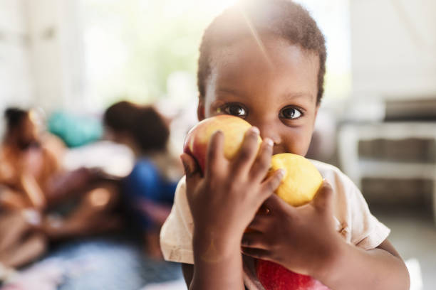 istock Cute black boy with fresh fruit at home. 2060040318