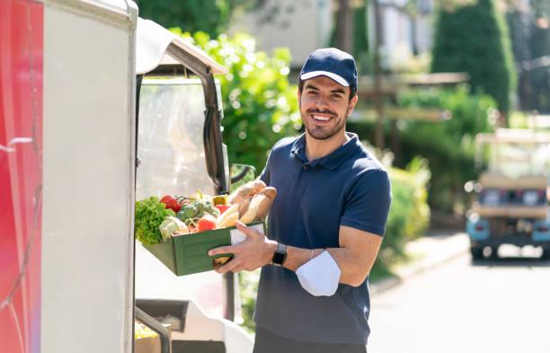 istock Young courier delivering crate with fresh food to client. 2060048562
