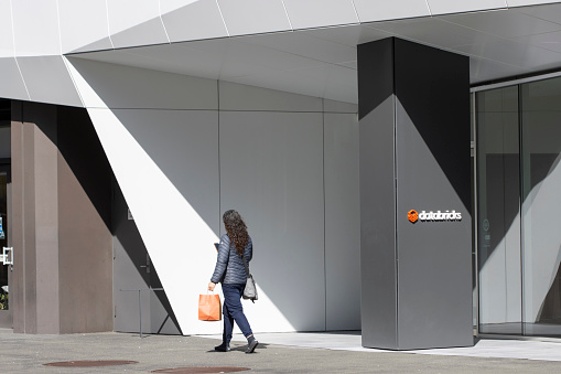 San Francisco, CA, USA - Feb 22, 2024: A woman walks past the entrance to the headquarters of Databricks, a software company founded by the original creators of Apache Spark, in San Francisco.