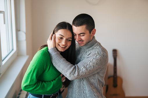 Happy embracing young couple enjoying after moving into a new home.
