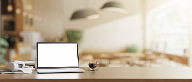 istock A wooden table features a white-screen laptop computer mockup in a modern Scandinavian coffee shop. 2060065751