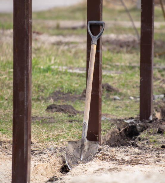 istock A worker digs the ground with a shovel to install a fence 2060102571