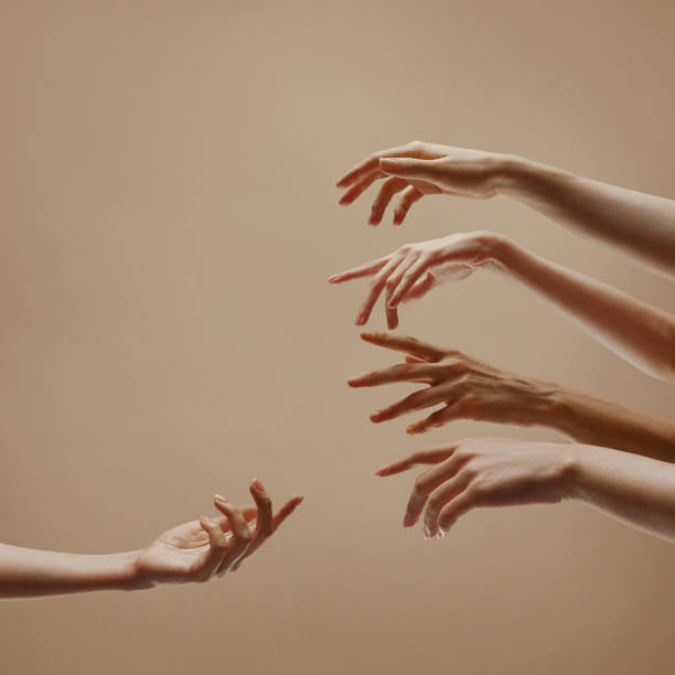 istock One hand reaching to other hands symbolizing support, community against sandy color studio background. 2060109594