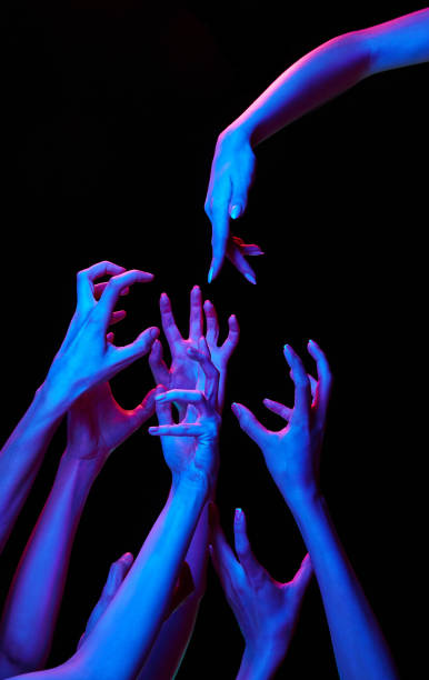 istock One pointing hand diving to group of hand showcasing negative in multicolored neon lighting against black studio background. 2060109622