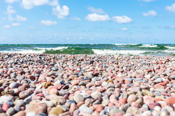 Small pebbles on the shore. sunny summer day blue sky,white clouds. beautiful lonely small pebble beach.Copy space.
