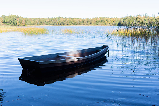 Wooden boat on the calm lake.old wooden boat on the water of a wide river in sunny autum,spring day
