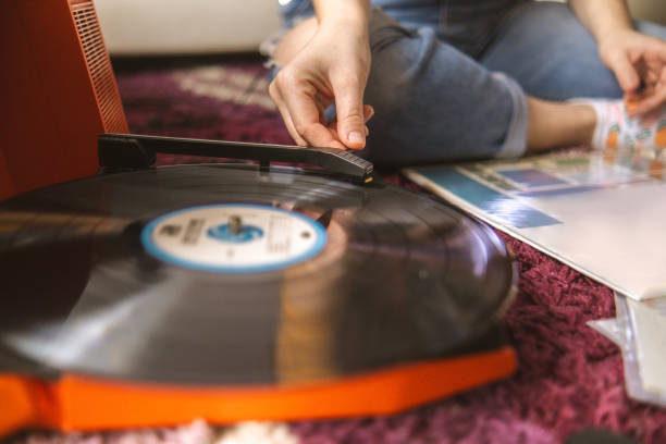 istock Young woman putting a record on her gramophone 2060117297