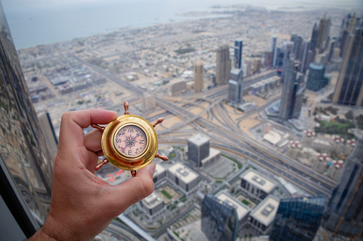 Hand holding compass in Dubai city