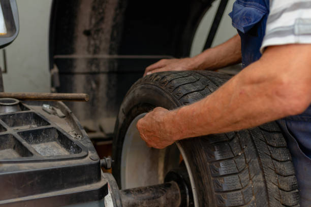 istock Car mechanic balancing car wheel on a computer machine balancer in auto repair service. 2060131466