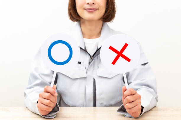 istock A woman answers using circle and cross placards. 2060135289