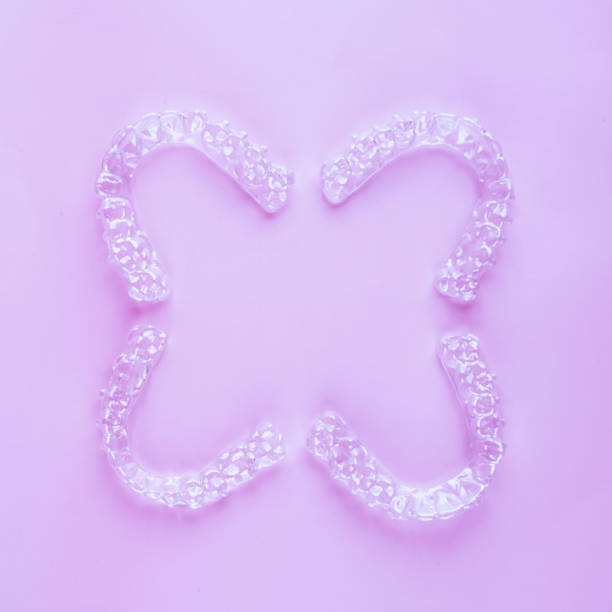 istock Invisible dental teeth brackets tooth aligners on pink background. Plastic braces dentistry retainers to straighten teeth. 2060136454