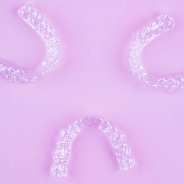 istock Invisible dental teeth brackets tooth aligners on pink background. Plastic braces dentistry retainers to straighten teeth. 2060136992