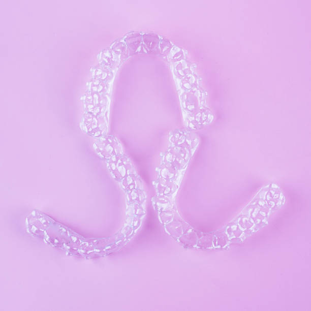 istock Invisible dental teeth brackets tooth aligners on pink background. Plastic braces dentistry retainers to straighten teeth. 2060138044