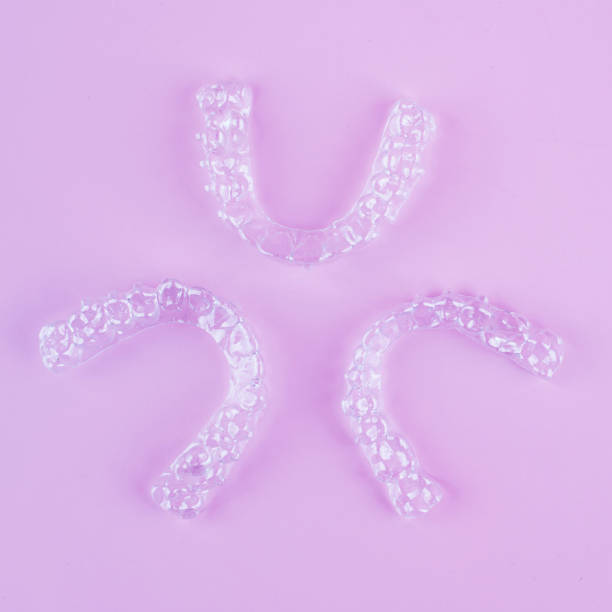 istock Invisible dental teeth brackets tooth aligners on pink background. Plastic braces dentistry retainers to straighten teeth. 2060138056