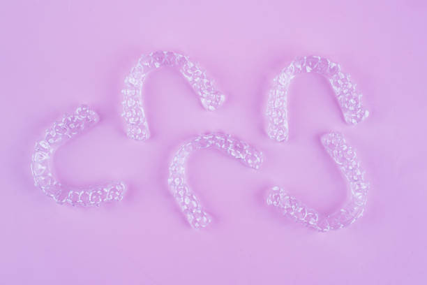 istock Invisible dental teeth brackets tooth aligners on pink background. Plastic braces dentistry retainers to straighten teeth. 2060139117