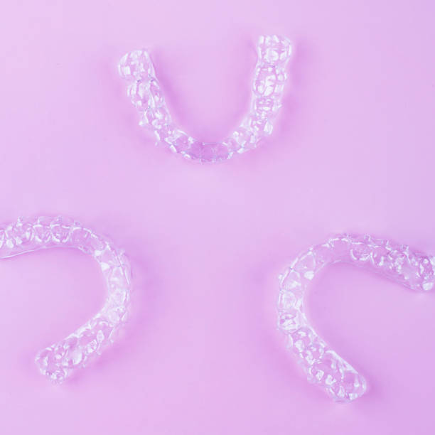 istock Invisible dental teeth brackets tooth aligners on pink background. Plastic braces dentistry retainers to straighten teeth. 2060140203