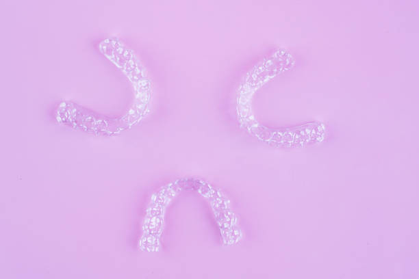 istock Invisible dental teeth brackets tooth aligners on pink background. Plastic braces dentistry retainers to straighten teeth. 2060140744