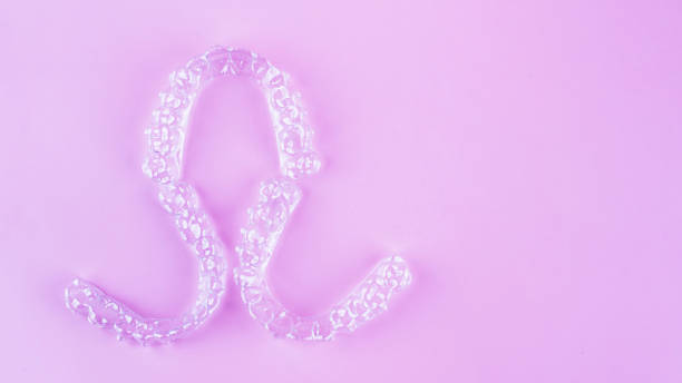istock Invisible dental teeth brackets tooth aligners on pink background. Plastic braces dentistry retainers to straighten teeth. 2060140768