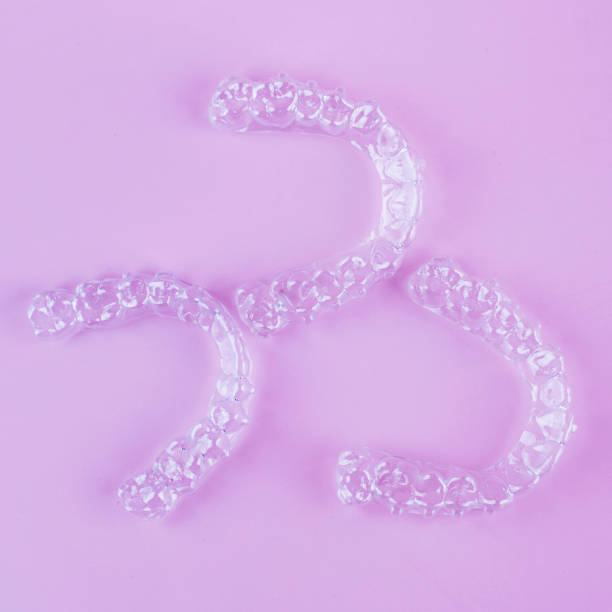 istock Invisible dental teeth brackets tooth aligners on pink background. Plastic braces dentistry retainers to straighten teeth. 2060142445