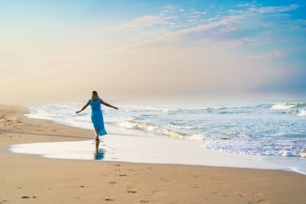 istock Beautiful woman walking on beach 2060146910