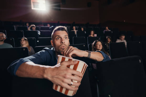 Surprised man watching a movie in cinema.